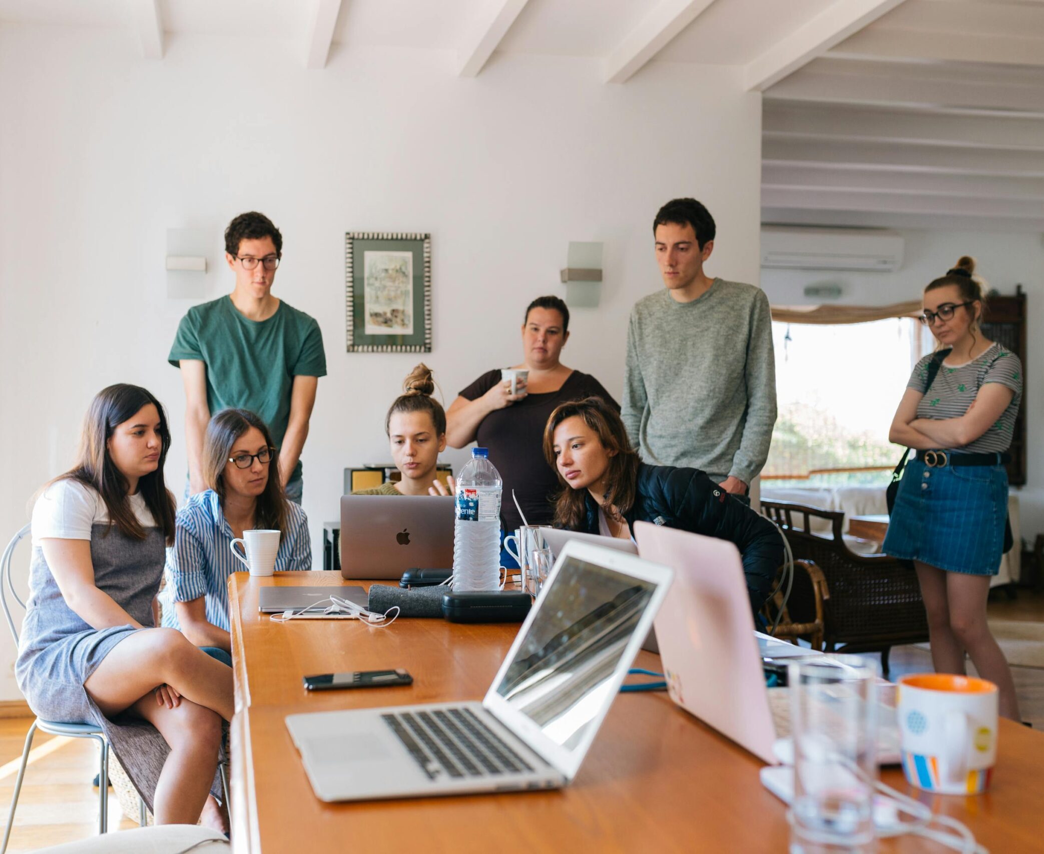 Group of young professionals engaged in a collaborative meeting in a modern office setting.